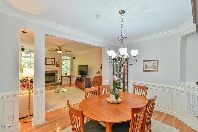 119 Jones Creek Pl Unit 119, Chapel Hill, NC 27516 - dining room with ornamental molding, light wood-type flooring, a fireplace, ceiling fan, and a wainscoted wall