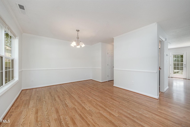 709 Woodgreen Dr, Durham, NC 27704 - unfurnished room featuring a chandelier, light wood finished floors, ornamental molding, and a textured ceiling