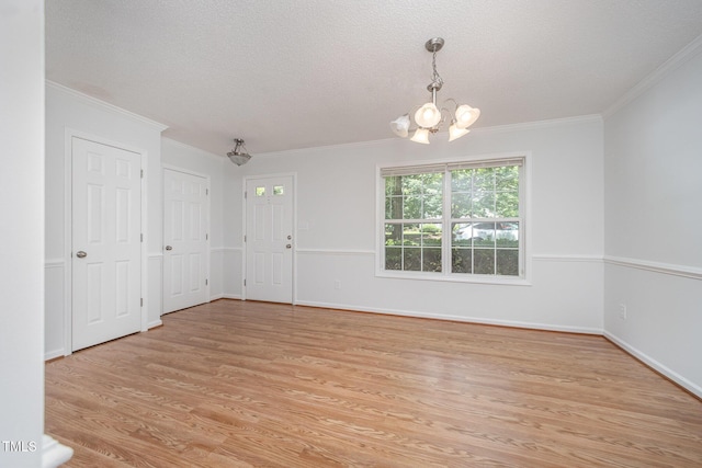 709 Woodgreen Dr, Durham, NC 27704 - empty room featuring a chandelier, light wood finished floors, crown molding, and a textured ceiling