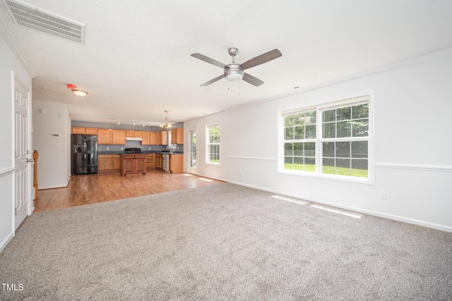 709 Woodgreen Dr, Durham, NC 27704 - unfurnished living room with light carpet, ceiling fan, crown molding, and a chandelier