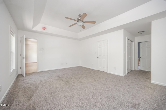 709 Woodgreen Dr, Durham, NC 27704 - unfurnished bedroom featuring a tray ceiling, carpet, and ceiling fan