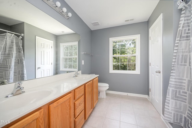 709 Woodgreen Dr, Durham, NC 27704 - full bath featuring healthy amount of natural light, double vanity, and tile patterned floors