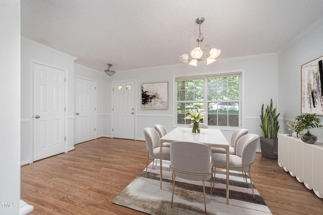709 Woodgreen Dr, Durham, NC 27704 - dining room with a chandelier, ornamental molding, wood finished floors, and a textured ceiling