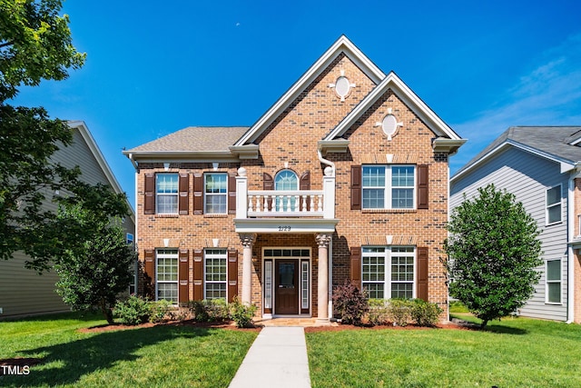 2129 Glade Valley Ln, Morrisville, NC 27560 - colonial house with brick siding, a front lawn, and a balcony