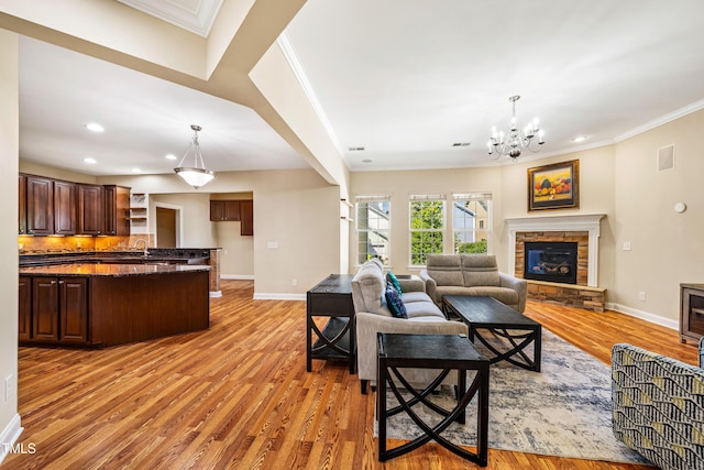 2129 Glade Valley Ln, Morrisville, NC 27560 - living room featuring light wood-style flooring, ornamental molding, a chandelier, a fireplace, and recessed lighting