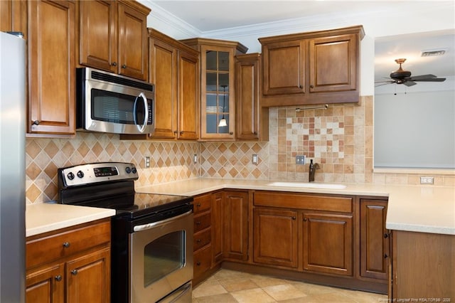 3310 Starboard Way Unit 301, Fayetteville, NC 28314 - kitchen with stainless steel appliances, ceiling fan, brown cabinets, light countertops, and tasteful backsplash