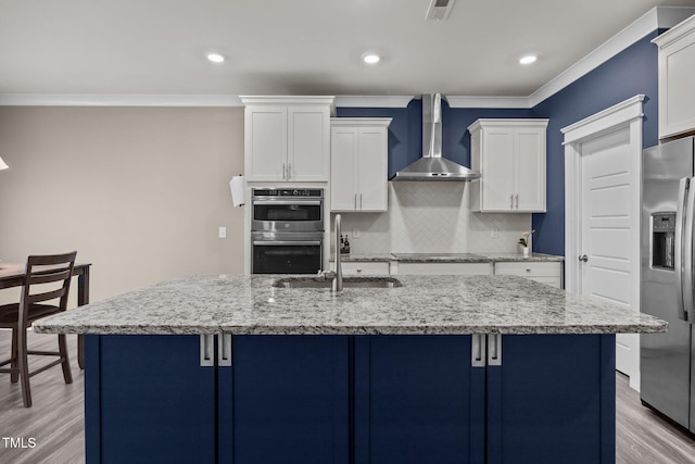 22 Combine Trl, Benson, NC 27504 - kitchen with appliances with stainless steel finishes, wall chimney exhaust hood, decorative backsplash, light stone countertops, and light wood-style flooring