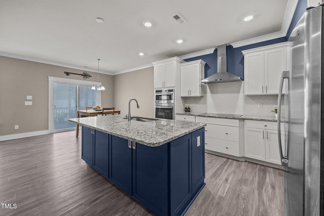22 Combine Trl, Benson, NC 27504 - kitchen featuring stainless steel appliances, wall chimney range hood, blue cabinetry, wood finished floors, and white cabinets