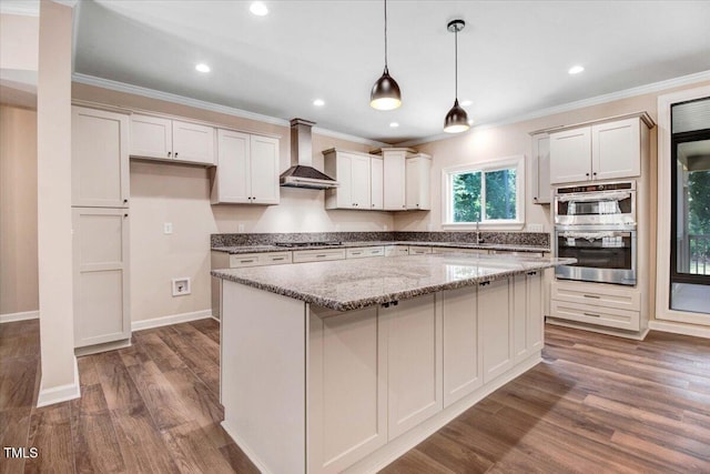 206 Tramway Pl, Goldsboro, NC 27534 - kitchen featuring wall chimney range hood, double oven, gas stovetop, crown molding, and a kitchen island