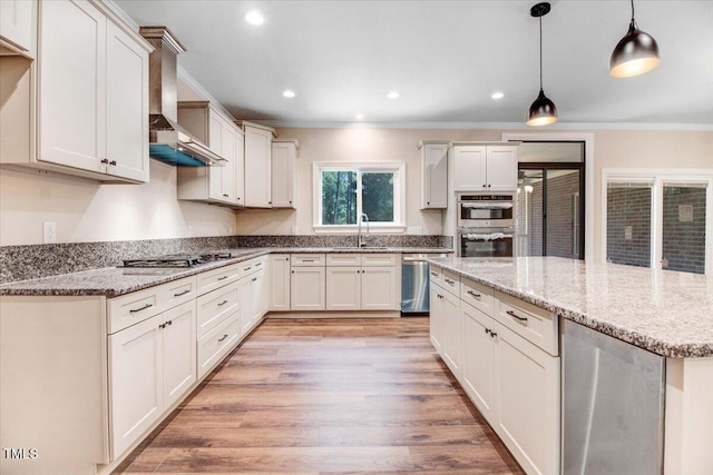 206 Tramway Pl, Goldsboro, NC 27534 - kitchen featuring stainless steel appliances, ornamental molding, wall chimney exhaust hood, light wood-style floors, and a center island