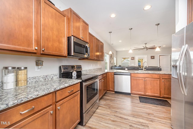 614 Marian Way, Sanford, NC 27330 - kitchen with appliances with stainless steel finishes, brown cabinetry, light wood-style floors, light stone counters, and hanging light fixtures