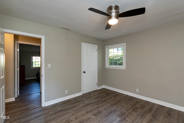 438 N Hickory St, Angier, NC 27501 - unfurnished bedroom with dark wood-type flooring, ceiling fan, and a textured ceiling