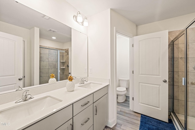 1137 Amber Shadow Dr, Durham, NC 27703 - bathroom featuring double vanity, a shower stall, and wood finished floors