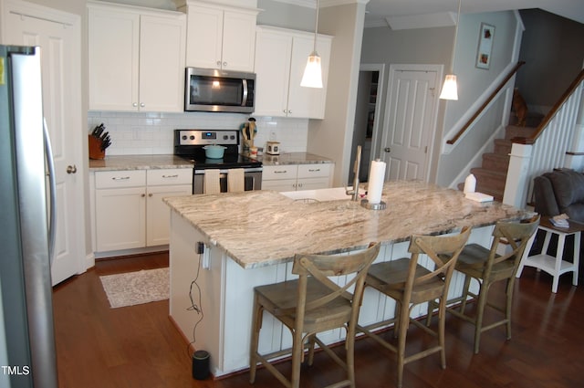 2471 Golden Forest Dr, Franklinton, NC 27525 - kitchen featuring appliances with stainless steel finishes, decorative backsplash, dark wood-style floors, light stone countertops, and ornamental molding