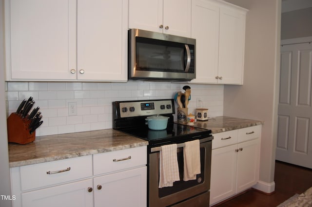 2471 Golden Forest Dr, Franklinton, NC 27525 - kitchen featuring appliances with stainless steel finishes, light stone countertops, decorative backsplash, and white cabinets