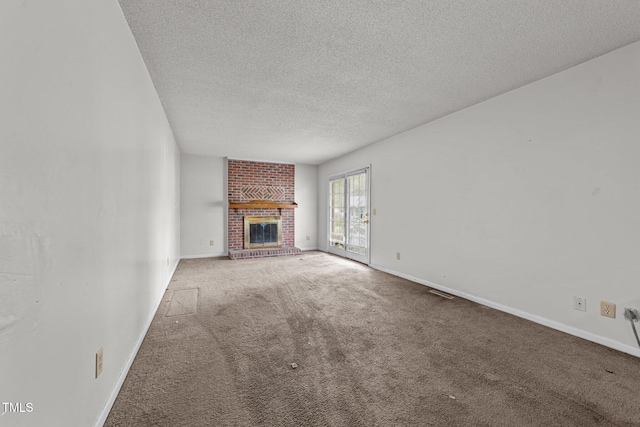 1402 Tarleton Ave, Burlington, NC 27215 - unfurnished living room featuring a textured ceiling, carpet floors, and a brick fireplace