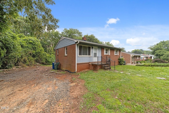 807 New St, Graham, NC 27253 - view of front of home with brick siding, a chimney, and a front lawn