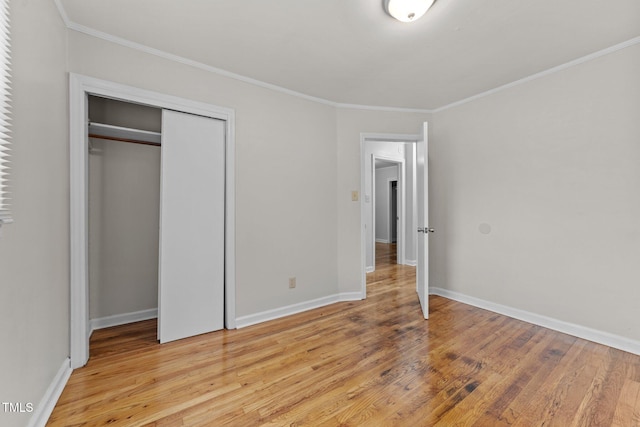 807 New St, Graham, NC 27253 - unfurnished bedroom with light wood-type flooring, ornamental molding, and a closet