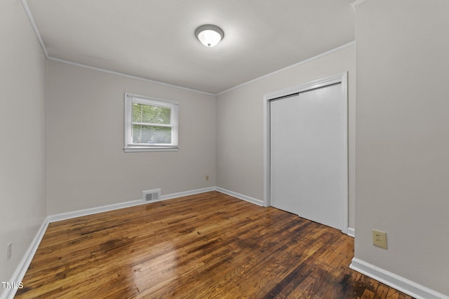807 New St, Graham, NC 27253 - unfurnished bedroom with ornamental molding, wood-type flooring, and a closet
