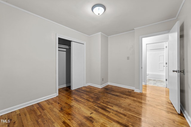 807 New St, Graham, NC 27253 - unfurnished bedroom with wood finished floors, crown molding, and a closet