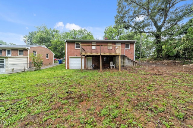 807 New St, Graham, NC 27253 - back of property featuring a deck, an attached garage, brick siding, and stairway
