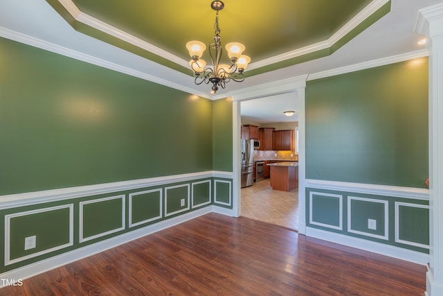 168 Melody Ln, Cameron, NC 28326 - unfurnished room with a chandelier, dark wood-type flooring, a raised ceiling, and ornamental molding