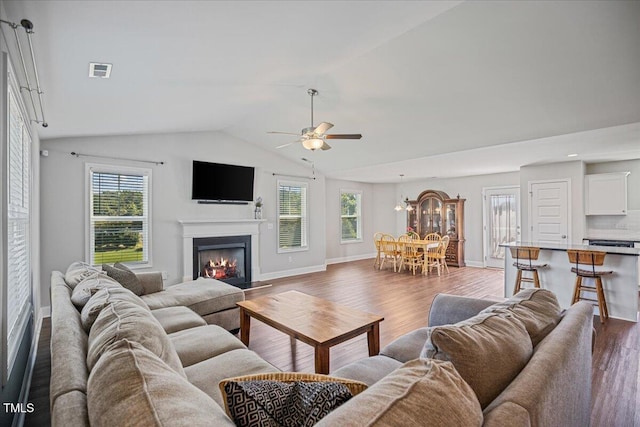 174 Arrow Ln, Middlesex, NC 27557 - living room with wood finished floors, vaulted ceiling, a warm lit fireplace, ceiling fan, and a chandelier