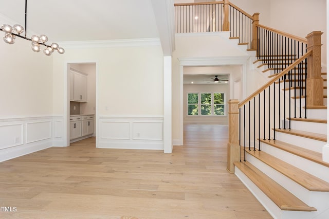 1417 Westmoreland Dr, Raleigh, NC 27612 - foyer entrance featuring a chandelier, a ceiling fan, crown molding, light wood-type flooring, and stairs