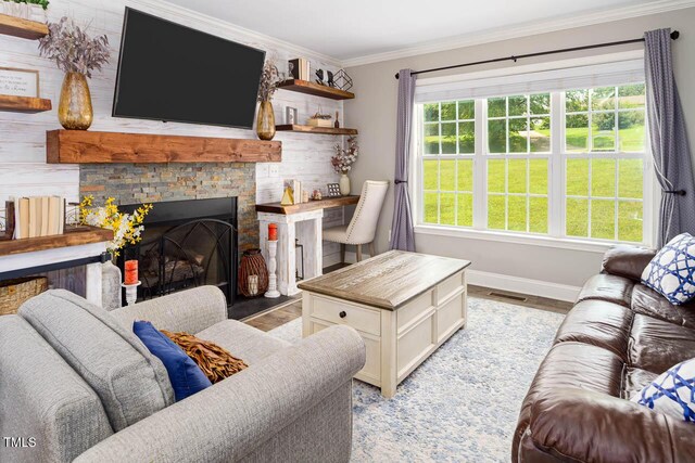3128 Bramblegate Dr, Mebane, NC 27302 - living room with light wood-style floors, ornamental molding, healthy amount of natural light, and a stone fireplace