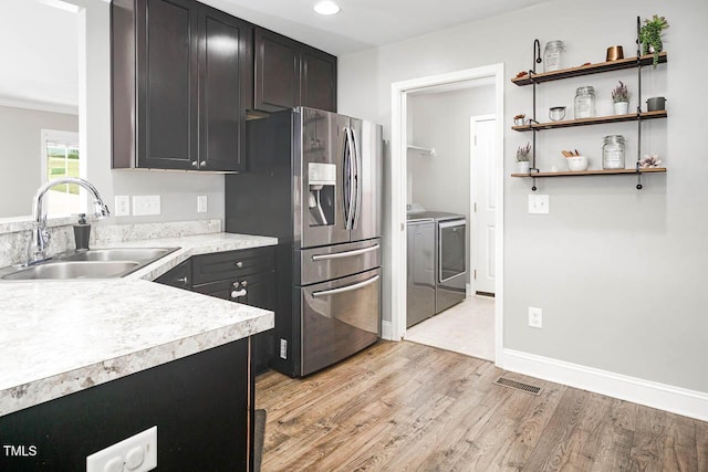 3128 Bramblegate Dr, Mebane, NC 27302 - kitchen with stainless steel fridge with ice dispenser, washer and dryer, light countertops, light wood finished floors, and recessed lighting
