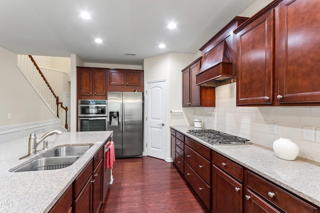 1320 Cozy Oak Ave, Cary, NC 27519 - kitchen featuring appliances with stainless steel finishes, premium range hood, dark wood finished floors, light stone countertops, and reddish brown cabinets