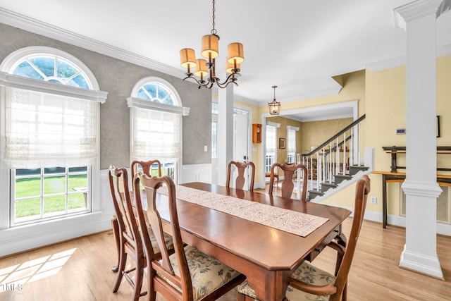 9009 Hometown Dr, Raleigh, NC 27615 - dining area featuring a chandelier, crown molding, light wood-type flooring, wainscoting, and decorative columns