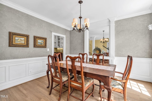 9009 Hometown Dr, Raleigh, NC 27615 - dining area featuring a chandelier, light wood-style flooring, crown molding, a decorative wall, and a wainscoted wall