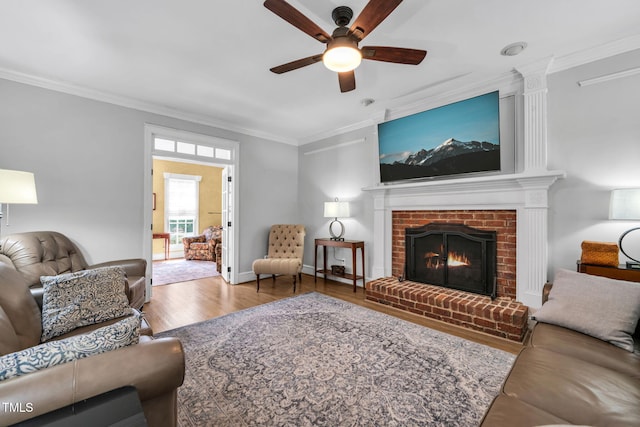 9009 Hometown Dr, Raleigh, NC 27615 - living area featuring crown molding, ceiling fan, wood finished floors, and a brick fireplace