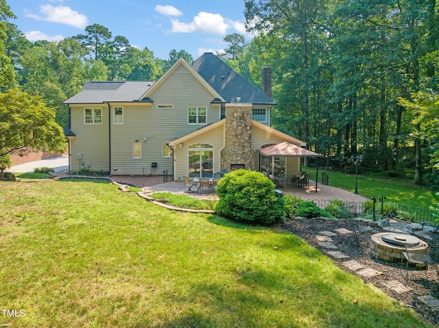 9009 Hometown Dr, Raleigh, NC 27615 - back of property with a fire pit, a patio area, a chimney, a lawn, and stone siding