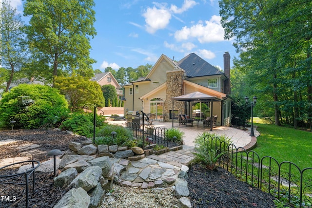 9009 Hometown Dr, Raleigh, NC 27615 - rear view of property featuring a gazebo, a chimney, a patio, and a lawn