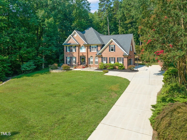 9009 Hometown Dr, Raleigh, NC 27615 - colonial-style house with concrete driveway, brick siding, and a front yard