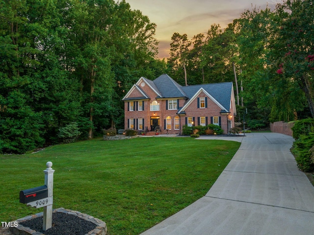 9009 Hometown Dr, Raleigh, NC 27615 - colonial home with a yard, driveway, and brick siding