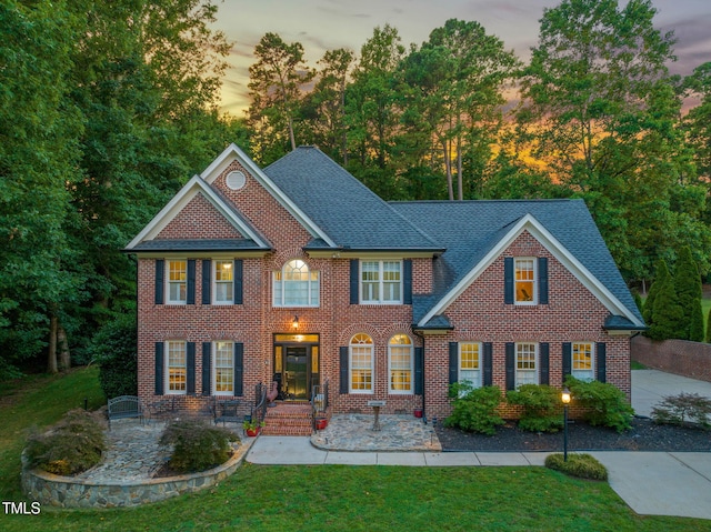 9009 Hometown Dr, Raleigh, NC 27615 - colonial inspired home with brick siding, a front yard, and roof with shingles