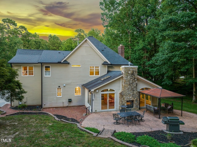 9009 Hometown Dr, Raleigh, NC 27615 - rear view of house featuring a patio, a chimney, a shingled roof, and a yard
