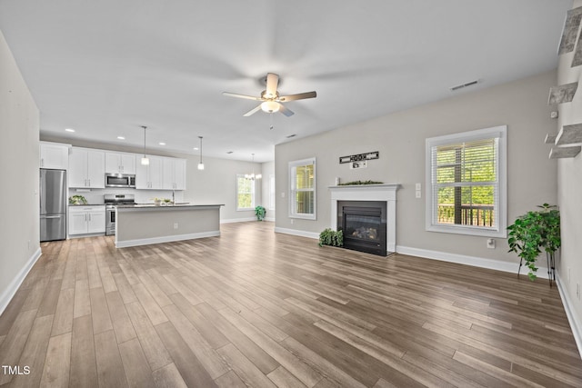 40 Cinnamon Teal Way, Youngsville, NC 27596 - unfurnished living room with a ceiling fan, a glass covered fireplace, light wood-type flooring, and recessed lighting