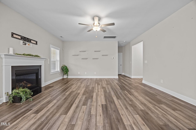 40 Cinnamon Teal Way, Youngsville, NC 27596 - unfurnished living room featuring wood finished floors, a ceiling fan, and a glass covered fireplace