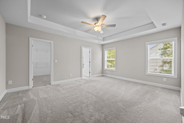 40 Cinnamon Teal Way, Youngsville, NC 27596 - unfurnished bedroom with a raised ceiling, a spacious closet, carpet flooring, and a ceiling fan