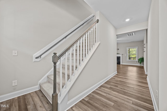 40 Cinnamon Teal Way, Youngsville, NC 27596 - stairs featuring wood finished floors, recessed lighting, and a glass covered fireplace