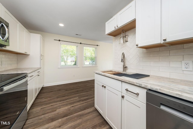 313 13th St, Butner, NC 27509 - kitchen with appliances with stainless steel finishes, dark wood-style floors, light stone counters, recessed lighting, and backsplash