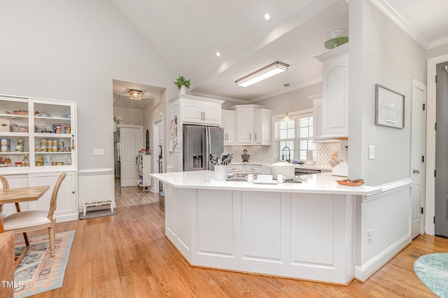 305 Maddux Dr, Pikeville, NC 27863 - kitchen with stainless steel fridge, white cabinets, ornamental molding, light wood finished floors, and light countertops