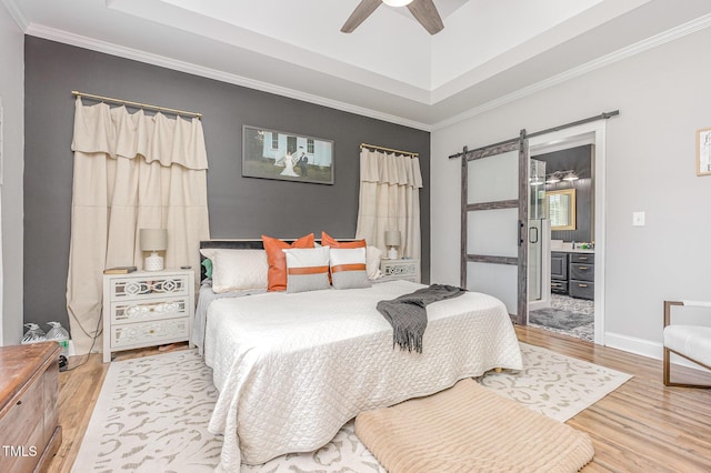 305 Maddux Dr, Pikeville, NC 27863 - bedroom featuring a barn door, wood finished floors, a raised ceiling, ornamental molding, and ensuite bathroom