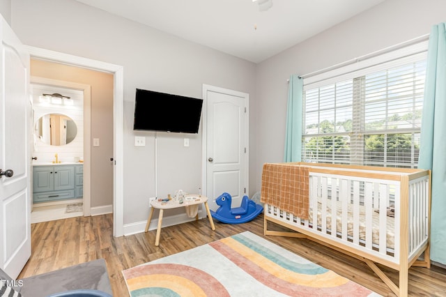 305 Maddux Dr, Pikeville, NC 27863 - bedroom featuring light wood finished floors and a crib