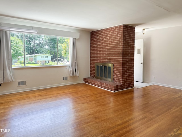 3323 Baugh St, Raleigh, NC 27604 - unfurnished living room featuring wood finished floors and a brick fireplace