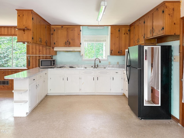 3323 Baugh St, Raleigh, NC 27604 - kitchen with freestanding refrigerator, stainless steel microwave, under cabinet range hood, open shelves, and light countertops